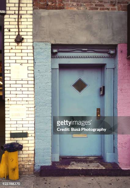 colorful front door and brick wall along dekalb avenue in brooklyn, new york city - schlechter zustand stock-fotos und bilder
