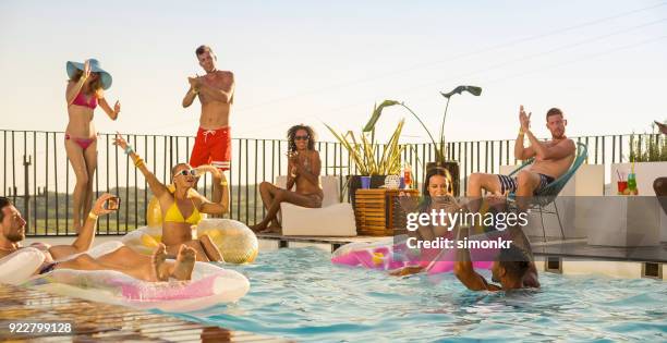 amigos disfrutando de la piscina - fiesta de piscina fotografías e imágenes de stock