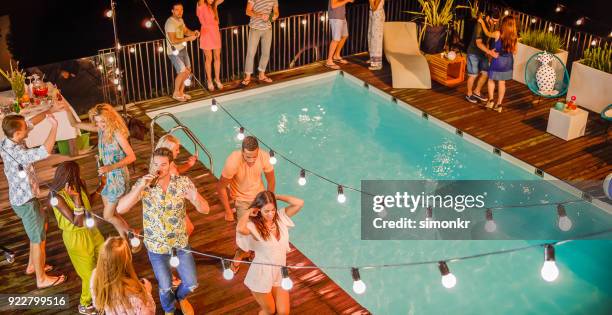 folk dansar och har god tid på natten party vid poolen - poolparty bildbanksfoton och bilder