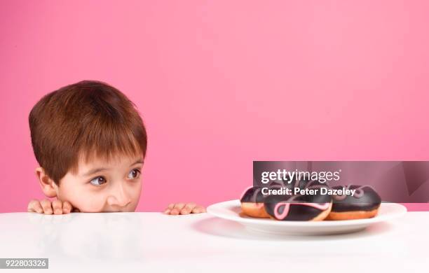 greedy boy looking at doughnuts - 欲張り ストックフォトと画像