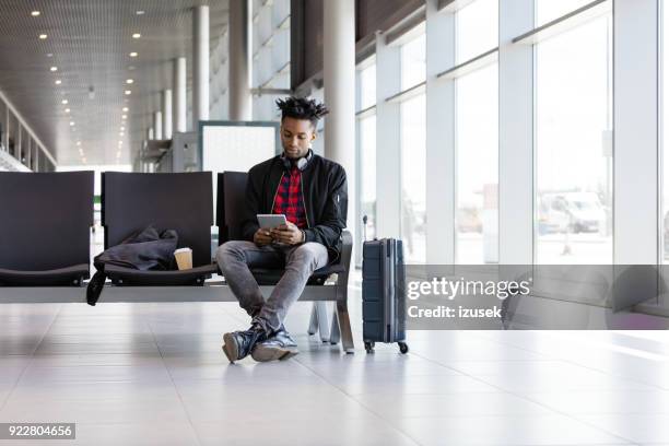 jonge afrikaanse digitale tablet met luchthaven lounge - passenger muzikant stockfoto's en -beelden