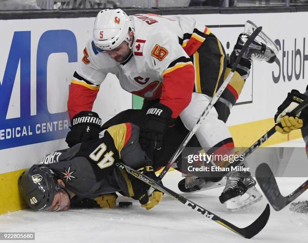 Mark Giordano of the Calgary Flames pushes Ryan Carpenter of the Vegas Golden Knights down as they go after a loose puck in the second period of...