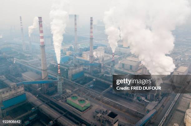 This aerial view taken on February 17, 2018 with a drone shows pollution being emitted from steel factories in Hancheng, Shaanxi province. / AFP...