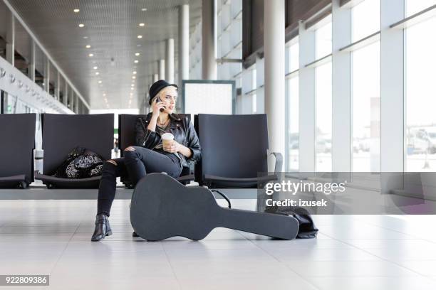 jonge funky blonde vrouw vlucht wachten in de luchthaven lounge - passenger muzikant stockfoto's en -beelden