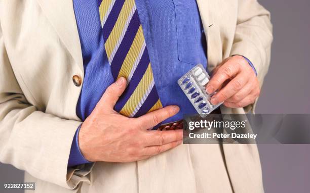 man with pills for stomach ache - celiac disease stock-fotos und bilder