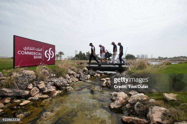 Scott Jamieson of Scotland, Marcel Siem of Germany and Chris Hanson of England cross a bridge during the first round of the Commercial Bank Qatar...