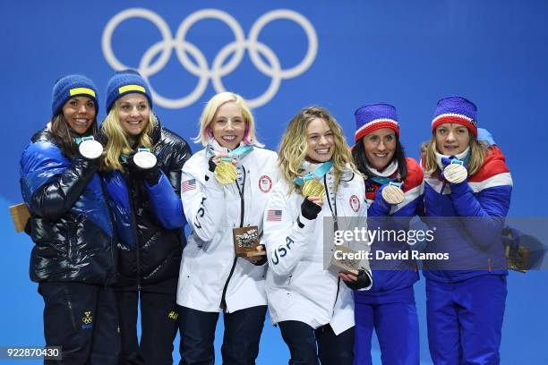 Silver medalists Charlotte Kalla and Stina Nilsson of Sweden, gold medalists Jessica Diggins and Kikkan Randall of the United States and bronze...
