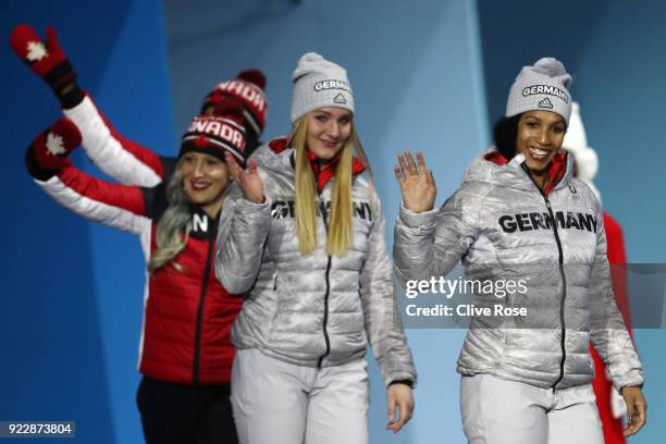 Gold medalists Lisa Buckwitz and Mariama Jamanka of Germany and bronze medalists Phylicia George and Kaillie Humphries of Canada walk on stage for...