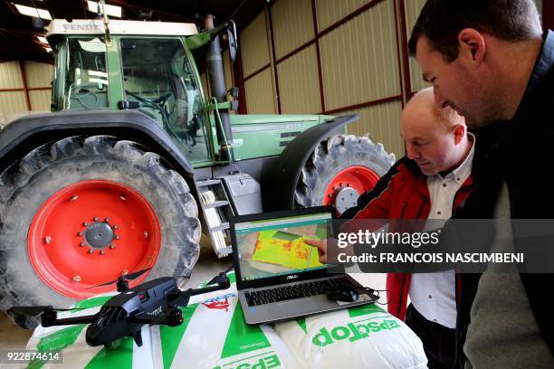 French farmer Cedric Jullien and a technician from Axe Environnement, which supplies tools for connected agriculture, study the images obtained from...