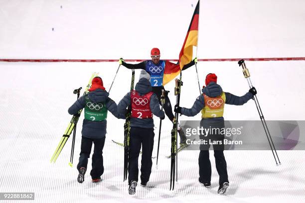 Johannes Rydzek of Germany celebrates winning gold with team mates Vinzenz Geiger of Germany, Fabian Riessle of Germany and Eric Frenzel of Germany...
