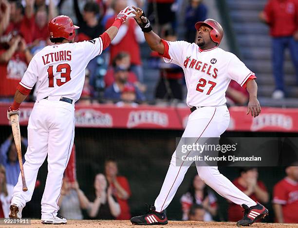 Vladimir Guerrero of the Los Angeles Angels of Anaheim celebrates with teammate Maicer Izturis during the first inning in Game Five of the ALCS...