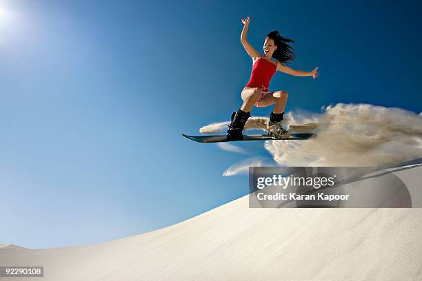 young female sandboarding - sand boarding stock pictures, royalty-free photos & images