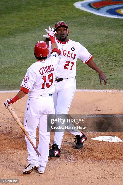Vladimir Guerrero of the Los Angeles Angels of Anaheim celebrates with teammate Maicer Izturis during the first inning in Game Five of the ALCS...