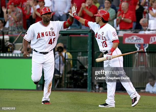 Torii Hunter of the Los Angeles Angels of Anaheim celebrates with teammate Maicer Izturis during the first inning in Game Five of the ALCS against...