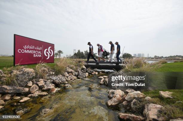 Scott Jamieson of Scotland, Marcel Siem of Germany and Chris Hanson of England cross a bridge during the first round of the Commercial Bank Qatar...