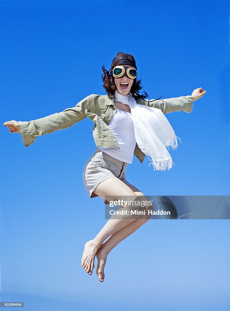 Woman Dressed as Aviator Jumping in Air