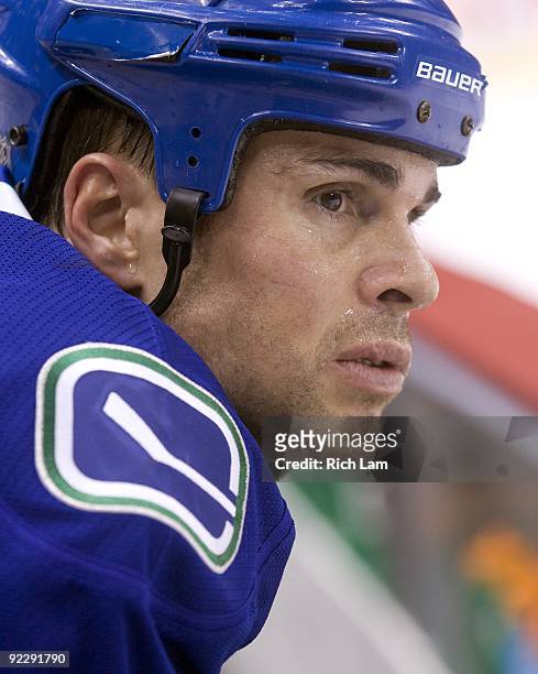 Defenceman Willie Mitchell of the Vancouver Canucks sits on the bench during the pre game warmup prior to the NHL game against the Minnesota Wild on...