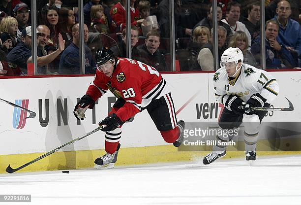 Jack Skille of the Chicago Blackhawks takes the puck up the boards as Toby Petersen of the Dallas Stars follows behind on October 17, 2009 at the...