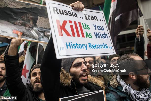 People hold signs and chant slogans during a protest against the Russian and Syrian forces bombing and blockade of the Syrian enclave of Eastern...