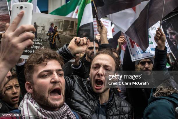 People hold signs and chant slogans during a protest against the Russian and Syrian forces bombing and blockade of the Syrian enclave of Eastern...