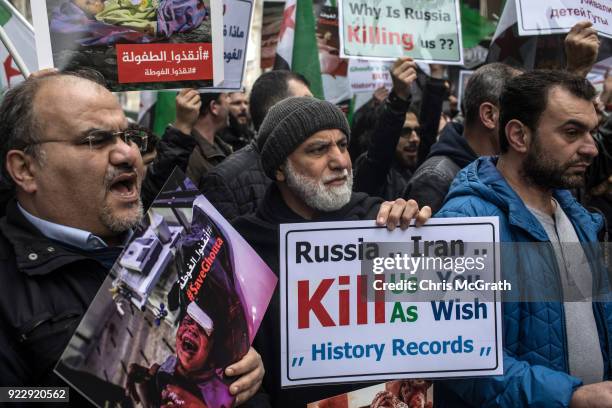 People hold signs and chant slogans during a protest against the Russian and Syrian forces bombing and blockade of the Syrian enclave of Eastern...