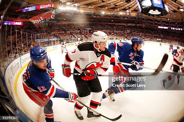 Ales Kotalik of the New York Rangers skates along the boards against Paul Martin of the New Jersey Devils on October 22, 2009 at Madison Square...