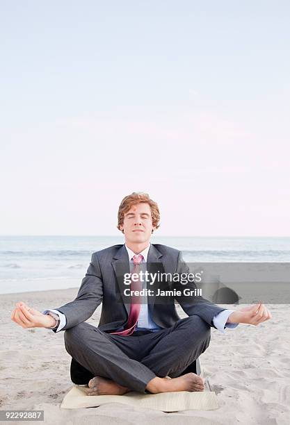 businessman meditating on beach - cross legged barefoot stock pictures, royalty-free photos & images