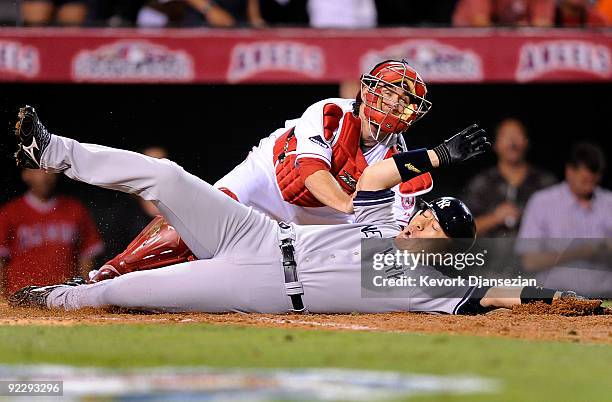 Hideki Matsui of the New York Yankees slides into home base safe ahead of Jeff Mathis of the Los Angeles Angels of Anaheim tag during the seventh...