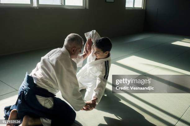 teen boy with his sansei practicing in dojo - teen martial arts stock pictures, royalty-free photos & images