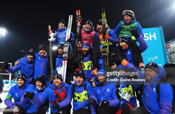 Bronze medalists Anais Bescond, Anais Chevalier, Justine Braisaz and Marie Dorin Habert of France celebrate with team mates and coaches after the...