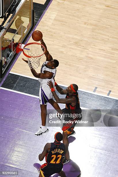 Desmond Mason of the Sacramento Kings shoots a layup against Stephen Jackson and Anthony Morrow of the Golden State Warriors during a preseason game...