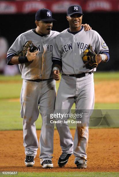Melky Cabrera of the New York Yankees talks with teammate Robinson Cano in Game Five of the ALCS against the Los Angeles Angels of Anaheim during the...