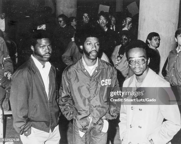 Three African-American students with afro haircuts stand among a crowd during an anti Vietnam War student sit-in protest at North Carolina State...