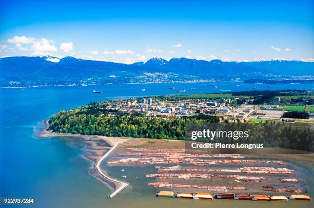 aerial view of log booms on the fraser delta with the university of british columbia and the coast mountain range in the background - vancouver, british columbia, canada - university of british columbia stock pictures, royalty-free photos & images