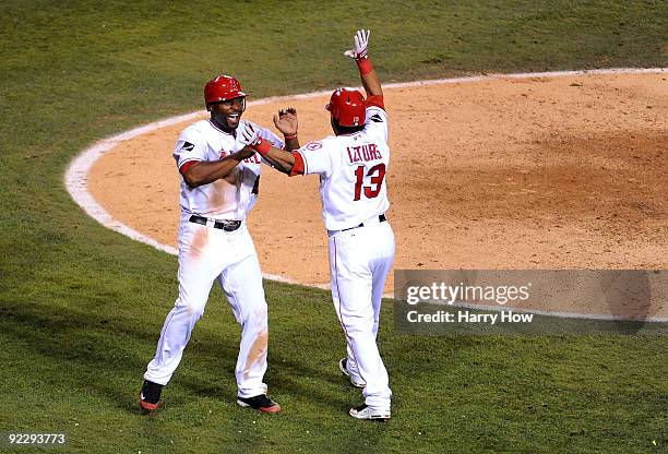 Torii Hunter of the Los Angeles Angels of Anaheim celebrates with teammate Maicer Izturis after scoring in the seventh inning in Game Five of the...