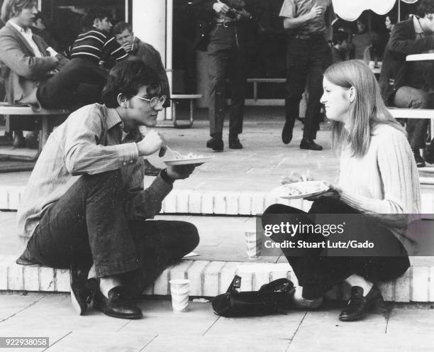 Male and female student, both wearing hippie attire, sit together on steps during an anti Vietnam War student sit-in protest at North Carolina State...