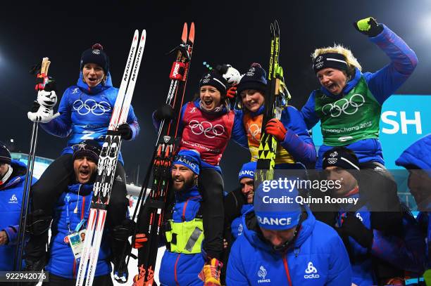 Bronze medalists Anais Bescond, Anais Chevalier, Justine Braisaz and Marie Dorin Habert of France celebrate with team mates and coaches after the...