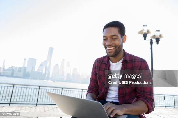 jonge man geniet van computer werk op city pier - omlaag kijken stockfoto's en -beelden