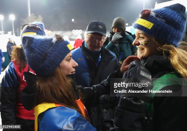 King Carl Gustaf of Sweden celebrates with silver medalists Linn Persson, Anna Magnusson and Mona Brorsson of Sweden after during the Women's 4x6km...
