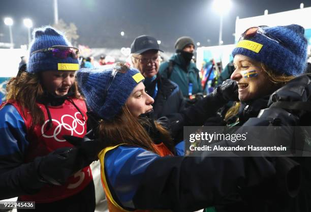 King Carl Gustaf of Sweden celebrates with silver medalists Linn Persson, Anna Magnusson and Mona Brorsson of Sweden after during the Women's 4x6km...