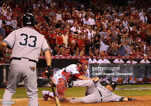 Hideki Matsui of the New York Yankees slides into home base safe ahead of Jeff Mathis of the Los Angeles Angels of Anaheim tag during the seventh...