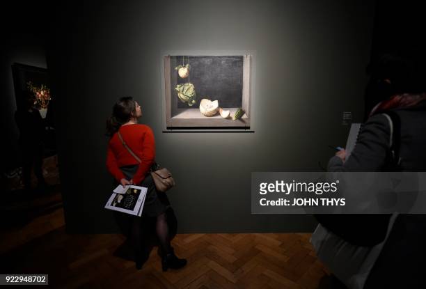 Visitors look at the painting 'Quince, Cabbage, Melon and Cucumber' by Spanish artist Juan Sanchez Cotan during a preview of the exhibition 'Spanish...