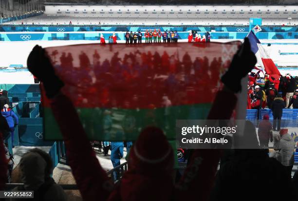 Fan holds a Belarus flag as Belarus win gold during the victory ceremony for the Women's 4x6km Relay on day 13 of the PyeongChang 2018 Winter Olympic...