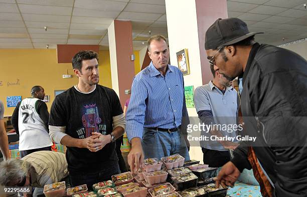 PLayer Nomar Garciaparra and Master of Ceremonies Jay Bilas pass out food to residents of the Tenderloin district at the Feeding America Food Bank on...