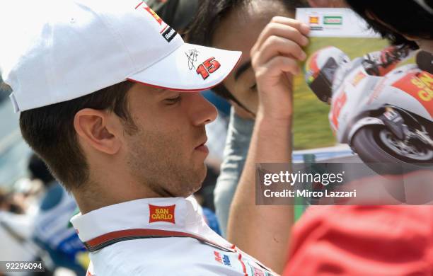 Alex De Angelis of Rep. San Marino and San Carlo Honda Gresini signs autographs for fans during the pit walk before practice for the Malaysian...