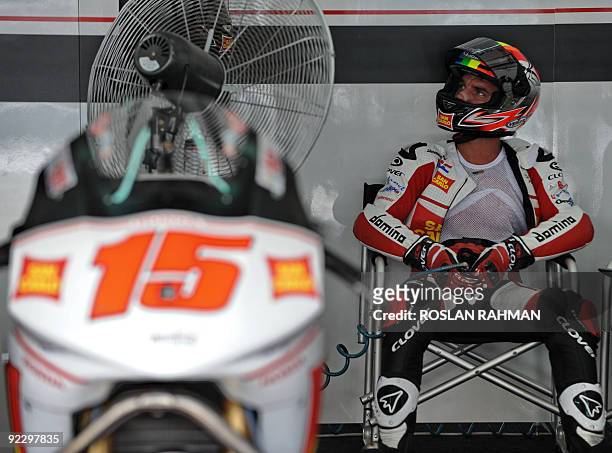 Alex de Angelis of San Marino rests in the pits at a free practice session during the Malaysian Motocycle Grand Prix in Sepang on October 23, 2009....