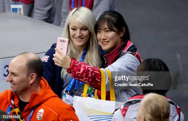 Elise Christie of Great Britain poses for selfies after attending the venue victory ceremony with her boyfriend Shaolin Sandor Liu of Hungary and his...