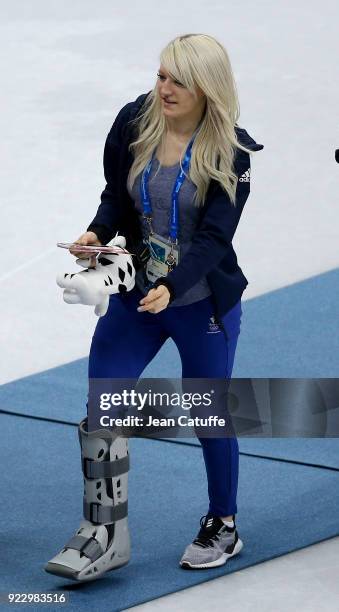 Elise Christie of Great Britain, with crutches wearing a cast on her right foot, looks on after attending the venue victory ceremony with her...