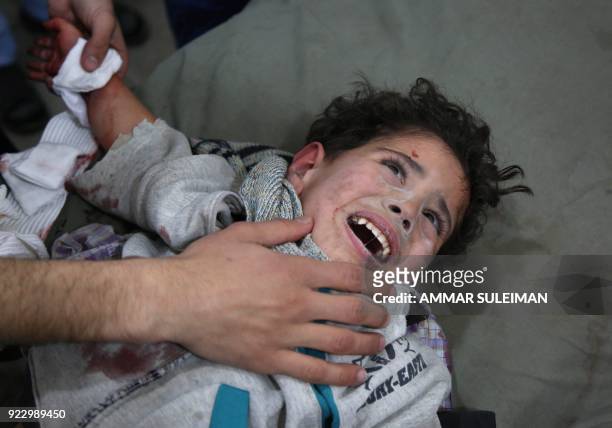 Wounded two-and-half Syrian child Mohammed Malas lies at a makeshift clinic following Syrian government bombardments in Kafr Batna, in the besieged...