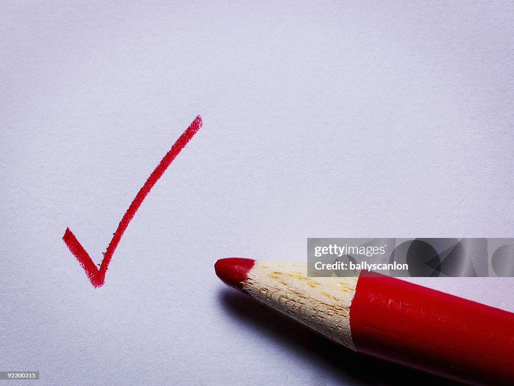 A Check Mark Written in Red Pencil.